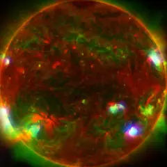 Färgrik bild av solen med lysande utbrott. Solens yta visar röda och gröna nyanser, med intensiva ljuspunkter som indikerar aktivitet.