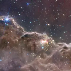 En lysande planetarisk nebulosa med stjärnor som glittrar i mörkret.