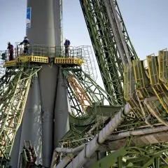 Arbetare inspekterar en raket vid Baikonur kosmodrom.