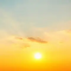 Solens strålar lyser upp himlen i en varm, gyllene ton. Molnen är mjuka och rosa, som om de fångar solnedgångens magi. En perfekt bild av sommarsolståndet.