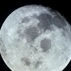 Detaljerad bild av månen med kratrar och mörka områden. Månens rotation gör att vi ser samma sida.