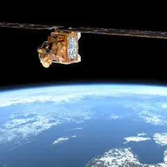En gyllene satellit svävar över en blå jord. Dess solpaneler sträcker sig ut, som om de samlar energi från rymden, medan en potentiell **debris field** lurar i mörkret.