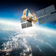 En satellit svävar över molnen. Hur många satelliter finns det egentligen i rymden? Månen syns i bakgrunden.