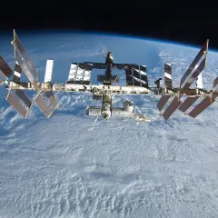 Den internationella rymdstationen, mir rymdstation, svävar över moln på jorden.