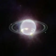 Neptunus ringar lyser i mörkret.