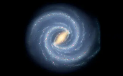 En bild av spiralformade galaxer med en ljusgul kärna och blåa armar fyllda med stjärnor och gas.