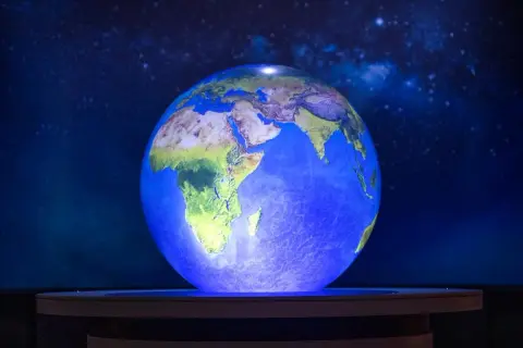 En lysande jordglob visar Afrika och Mellanöstern, med en stjärnklar bakgrund. Känns det som att jorden snurrar snabbare?