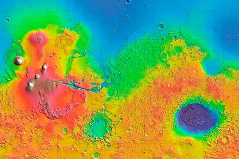 Färgkodad topografisk karta över Mars, visar höjdskillnader. Ett dygn på Mars avslöjar vulkaner och kratrar i olika färger.