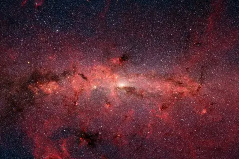 En glödande röd nebulosa fylld av stjärnor, som visar vad universum består av.