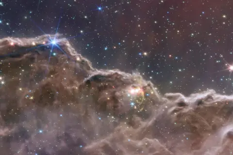 En lysande planetarisk nebulosa med stjärnor som glittrar i mörkret.