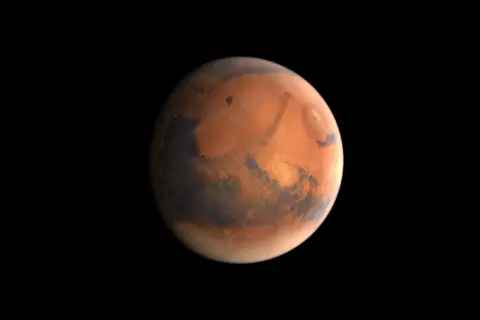 Mars massa, den röda planeten, med sina mörka och ljusa områden, svävar i rymdens svärta.