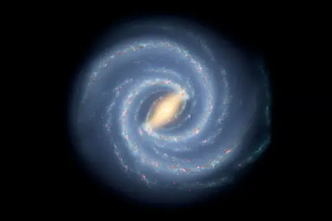 En bild av spiralformade galaxer med en ljusgul kärna och blåa armar fyllda med stjärnor och gas.