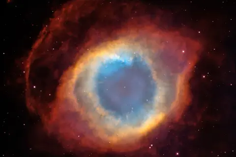 Enormt kosmiskt öga av gas och stoft, en **veil nebula** som lyser i blått, gult och rött.