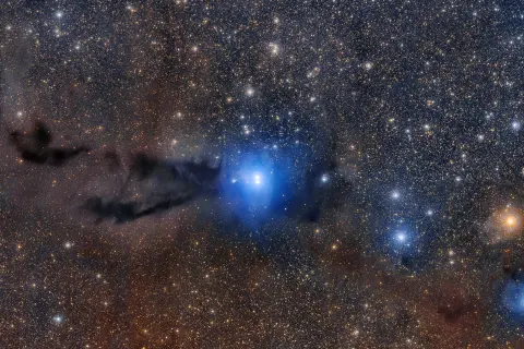 En blå nebulosa lyser upp mörka gasmoln, en fascinerande inblick i hur bildas en nebulosa.