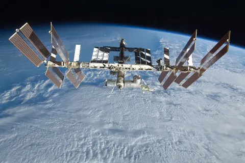Den internationella rymdstationen, mir rymdstation, svävar över moln på jorden.