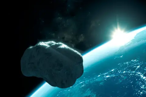 En stor asteroid svävar nära jorden. Solen går upp över planeten, som lyser med stadsljus.