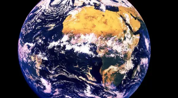 Jorden snurrar, med Afrika tydligt synligt. Moln virvlar över blå hav och gulbruna landmassor.