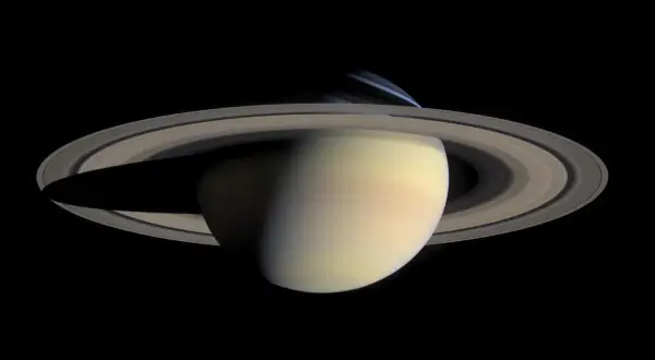 Saturnus med sina ringar, där nattsidan visar den kalla saturnus temperatur.