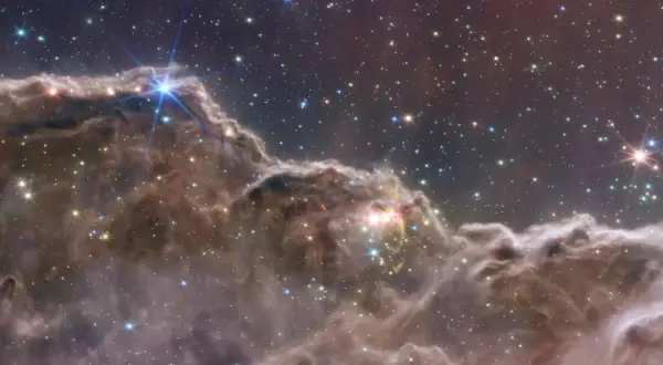 En lysande planetarisk nebulosa med stjärnor som glittrar i mörkret.