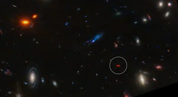En avlägsen galax, likt en glödande orion nebulosan, lyser i mörkret bland andra kosmiska objekt.