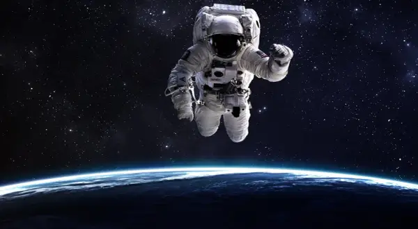 En astronaut svävar fritt i rymden, med jorden synlig under.