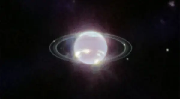 Neptunus ringar lyser i mörkret.