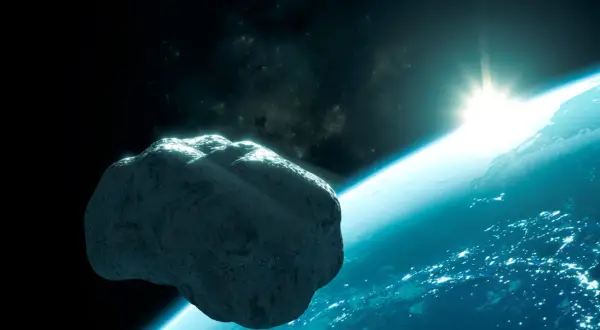 En stor asteroid svävar nära jorden. Solen går upp över planeten, som lyser med stadsljus.