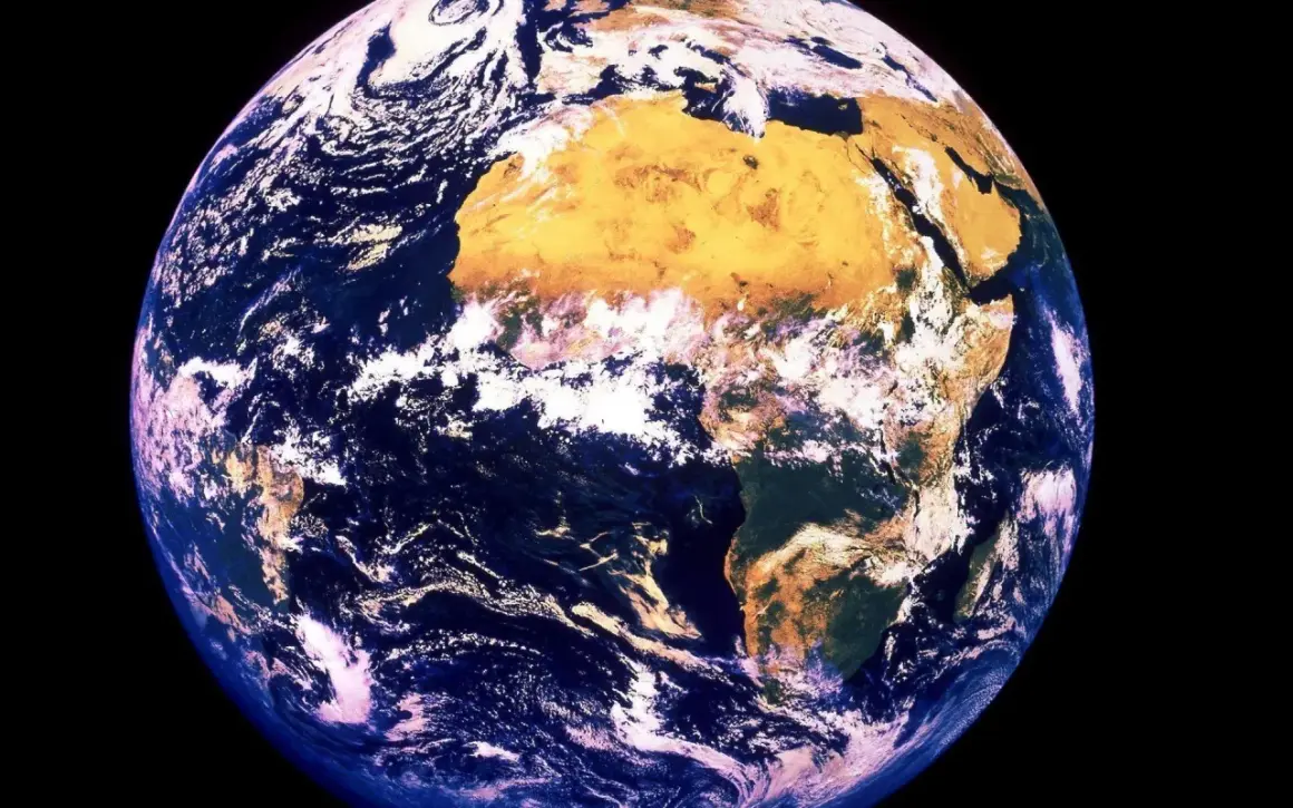 Jorden snurrar, med Afrika tydligt synligt. Moln virvlar över blå hav och gulbruna landmassor.