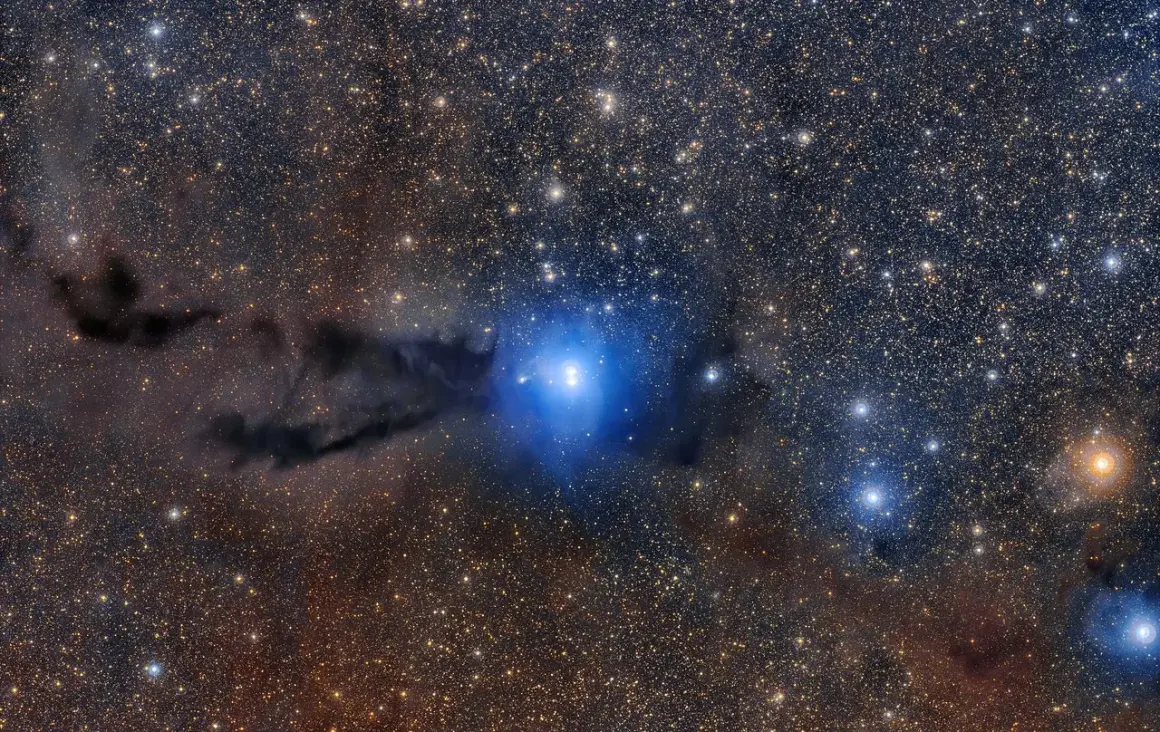 En blå nebulosa lyser upp mörka gasmoln, en fascinerande inblick i hur bildas en nebulosa.