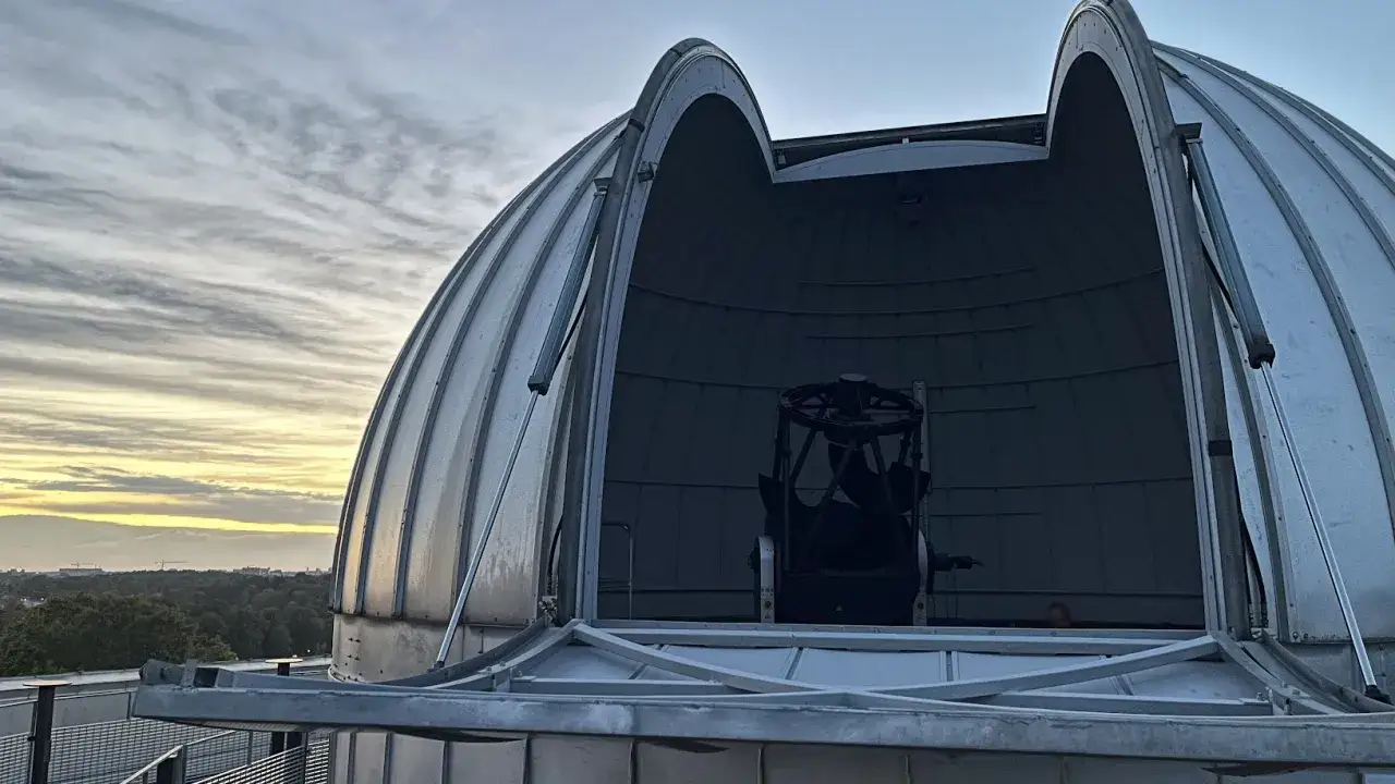 Observatoriedom med teleskop, perfekt för astronomi utbildning. Molnen på himlen skapar en dramatisk bakgrund.