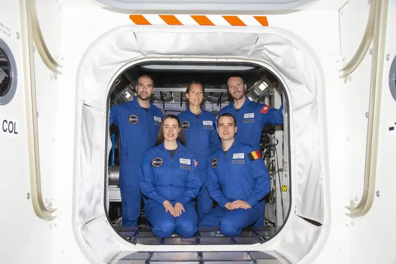 Fem astronauter i blå dräkter poserar i en rymdfarkost. De är redo för sin ESA-utbildning online.