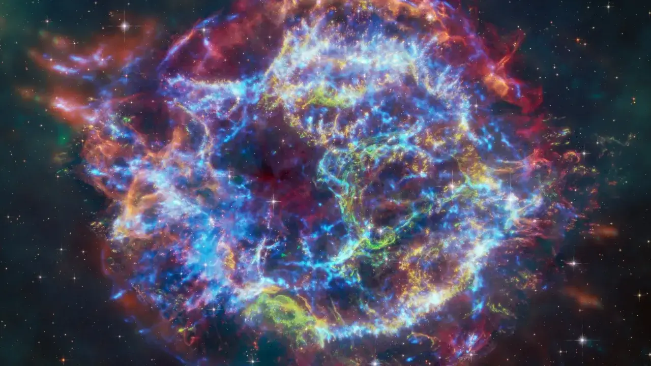 En f&auml;rgsprakande planetarisk nebulosa med virvlande gaser i bl&aring;tt, gr&ouml;nt och r&ouml;tt, omgiven av stj&auml;rnor.