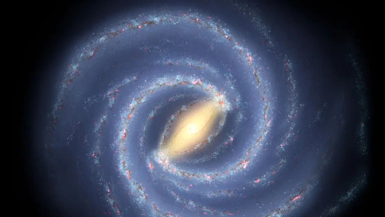 V&aring;r galax, Vintergatan, sett fr&aring;n ovan. Dess spiralarmar av stj&auml;rnor och gas virvlar runt en ljus k&auml;rna. Solens hastighet &auml;r enorm n&auml;r den f&auml;rdas genom denna kosmiska dans.