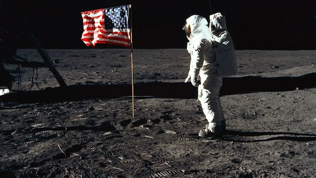 En astronaut står bredvid en amerikansk flagga på månen. Det är en ikonisk bild som visar buzz på månen.
