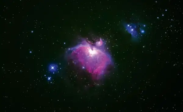Orionnebulosan lyser i lila och rosa, omgiven av stjärnor. Kanske är universum oändligt, med fler sådana skönheter bortom vår syn.