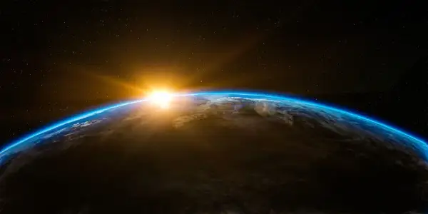 Jordens krökning med en glödande soluppgång över molnen. En påminnelse om liv i rymden och vår plats i universum.